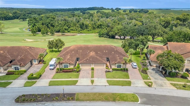 drone / aerial view with view of golf course and a forest view