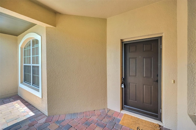 view of exterior entry with stucco siding