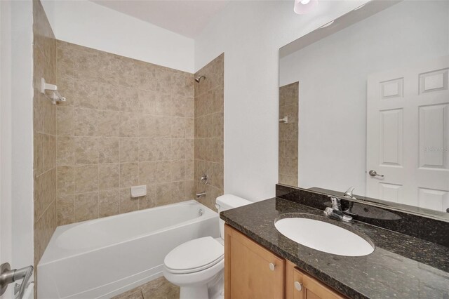 full bathroom with vanity, tiled shower / bath combo, toilet, and tile patterned flooring