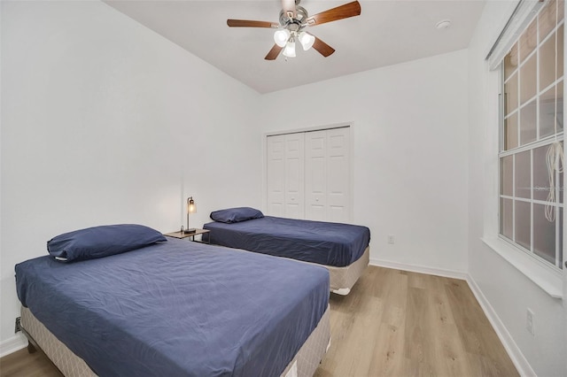 bedroom with ceiling fan, light hardwood / wood-style flooring, and a closet