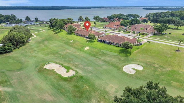 drone / aerial view with a water view and golf course view