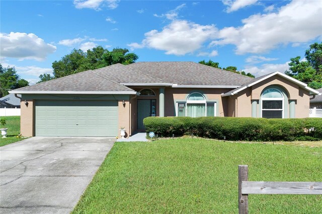 ranch-style home featuring a front lawn and a garage