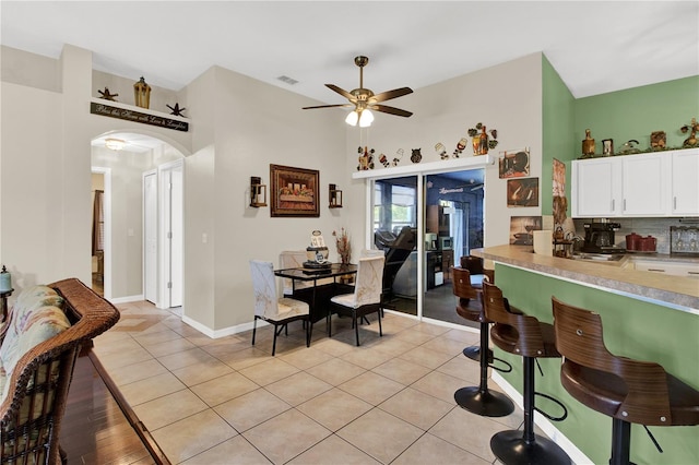 kitchen featuring ceiling fan, light tile patterned flooring, tasteful backsplash, and white cabinets