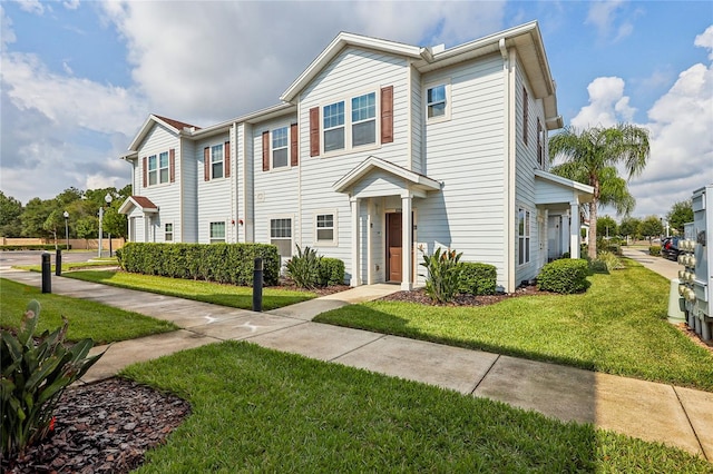 townhome / multi-family property featuring a front lawn