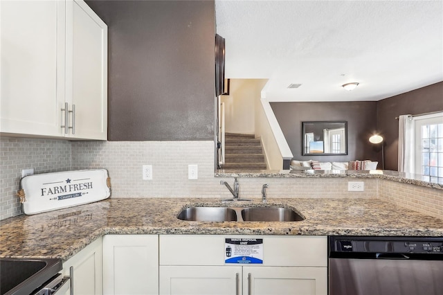 kitchen featuring sink, decorative backsplash, stainless steel dishwasher, and white cabinetry