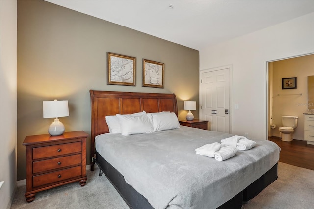 bedroom with light hardwood / wood-style floors and connected bathroom