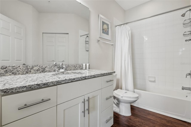 full bathroom featuring hardwood / wood-style flooring, toilet, shower / bath combo with shower curtain, and vanity