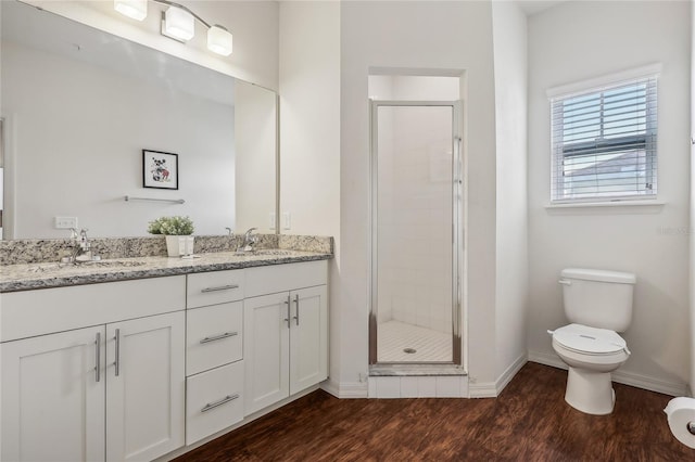 bathroom featuring walk in shower, hardwood / wood-style floors, dual vanity, and toilet