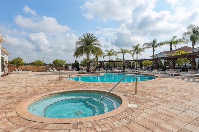 view of swimming pool featuring a hot tub and a patio area