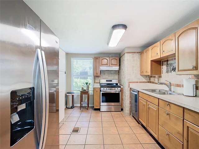 kitchen featuring sink, backsplash, light brown cabinets, appliances with stainless steel finishes, and light tile patterned floors