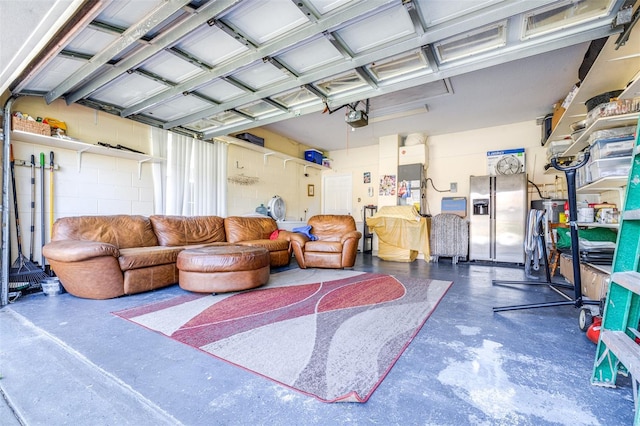 garage featuring stainless steel fridge with ice dispenser and a garage door opener