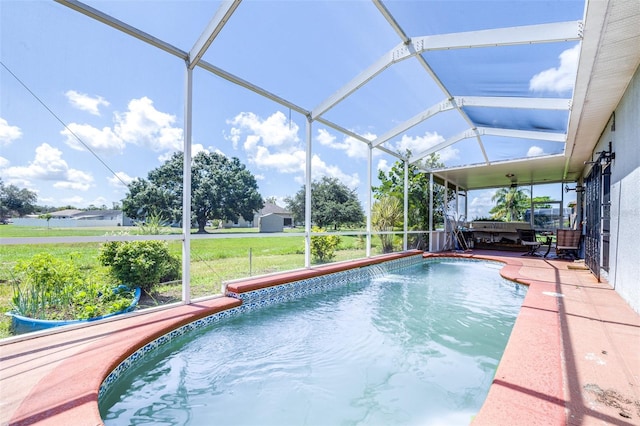 view of pool featuring glass enclosure, pool water feature, and a yard