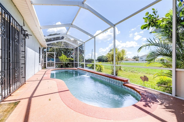 view of pool featuring a patio, pool water feature, a lanai, and a lawn