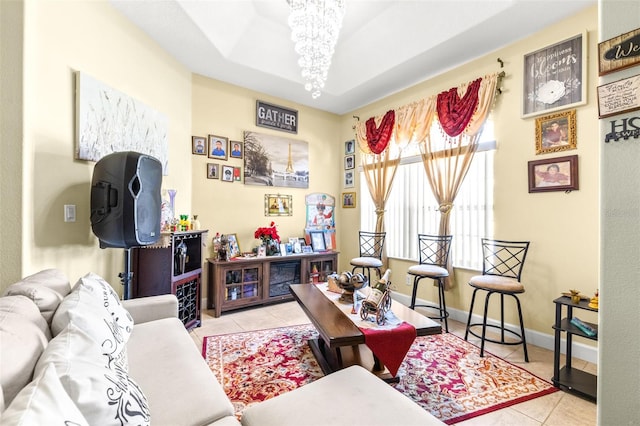 tiled living room with a raised ceiling and a chandelier