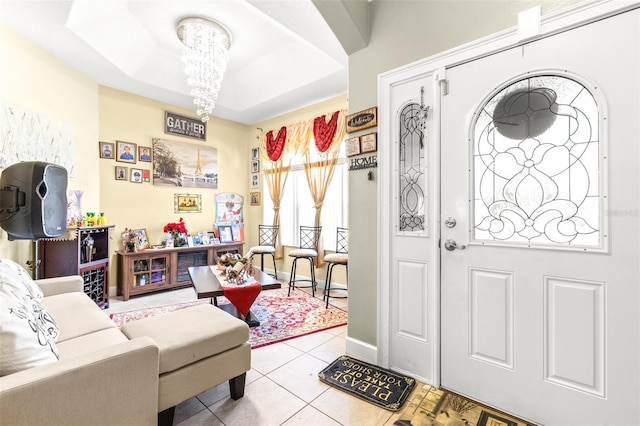 entryway featuring a raised ceiling, an inviting chandelier, and light tile patterned floors