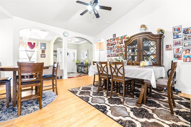 dining room featuring ceiling fan, high vaulted ceiling, and light wood-type flooring