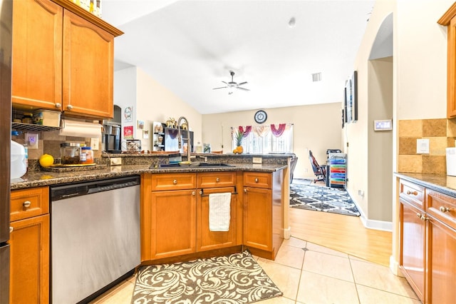 kitchen featuring dishwasher, light hardwood / wood-style floors, dark stone counters, ceiling fan, and kitchen peninsula