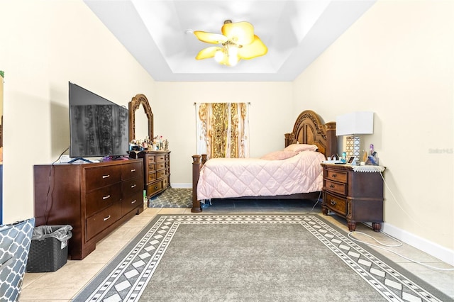 bedroom featuring light tile patterned floors and a raised ceiling