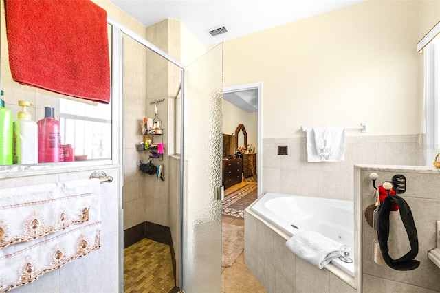 bathroom featuring tile walls, tile patterned floors, and separate shower and tub