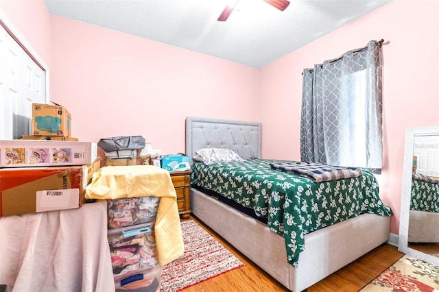 bedroom featuring ceiling fan, light hardwood / wood-style flooring, and a closet