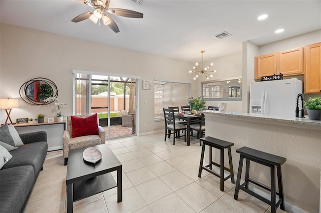 tiled living room featuring sink and ceiling fan with notable chandelier