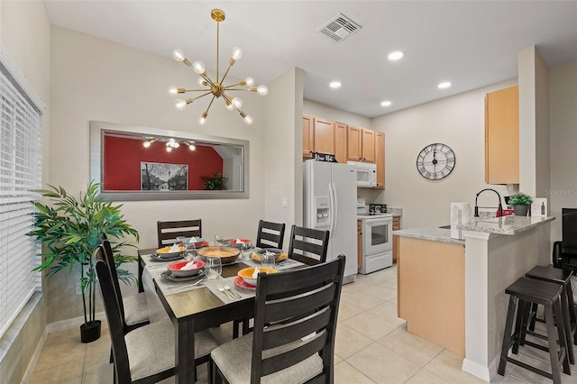 dining room with a notable chandelier, light tile patterned floors, and sink