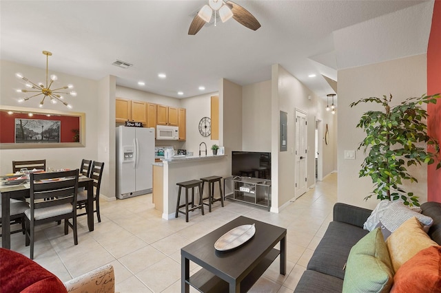 tiled living room with sink and ceiling fan with notable chandelier