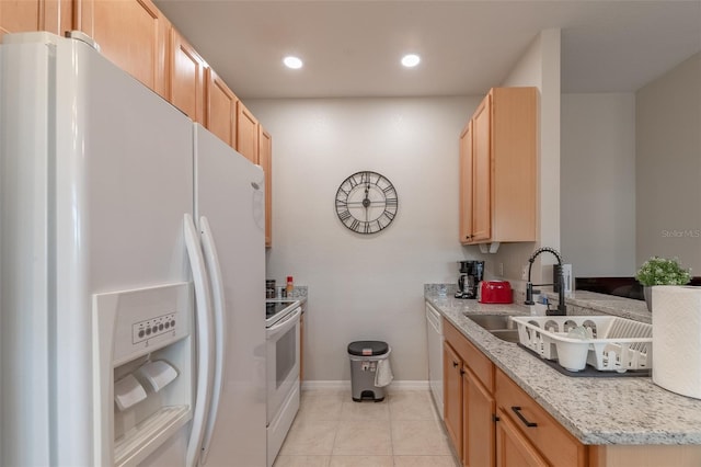 kitchen with light tile patterned floors, white appliances, and light brown cabinetry