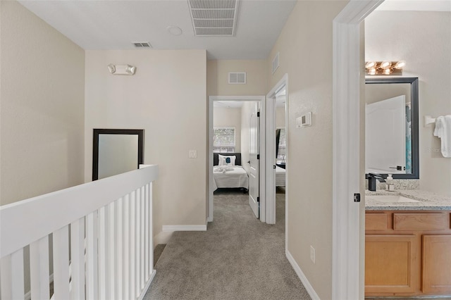 hall with light carpet and sink