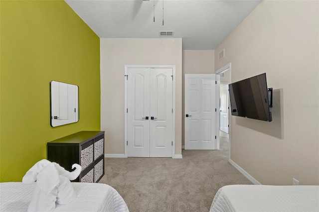 bedroom with light carpet and a closet