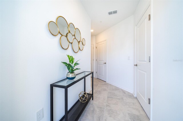 hall featuring light tile patterned floors