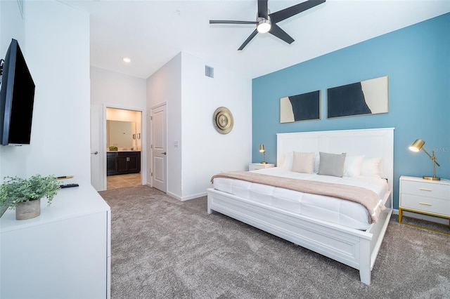 bedroom featuring baseboards, visible vents, light colored carpet, ensuite bath, and ceiling fan