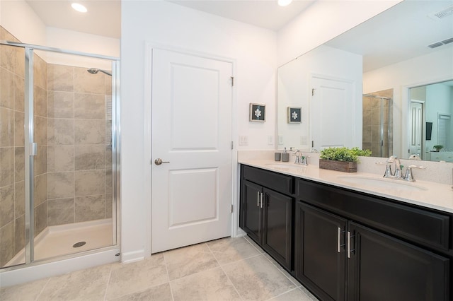 full bathroom featuring double vanity, a shower stall, visible vents, and a sink