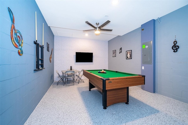 game room with speckled floor, billiards, a ceiling fan, and concrete block wall