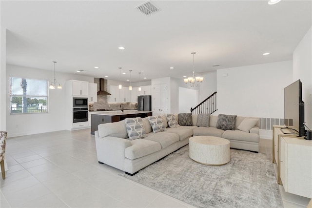 living room with light tile patterned flooring, a chandelier, and sink