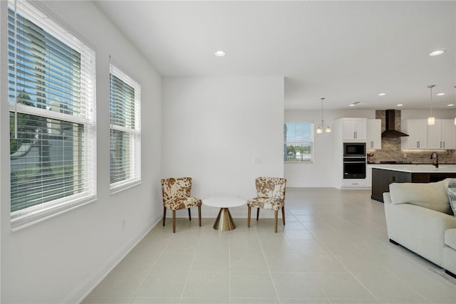 sitting room with light tile patterned floors, a chandelier, and a wealth of natural light