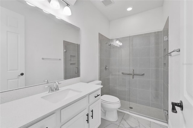 bathroom featuring toilet, vanity, and a shower with door