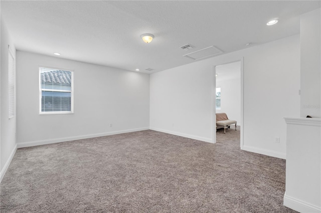 carpeted empty room with a textured ceiling