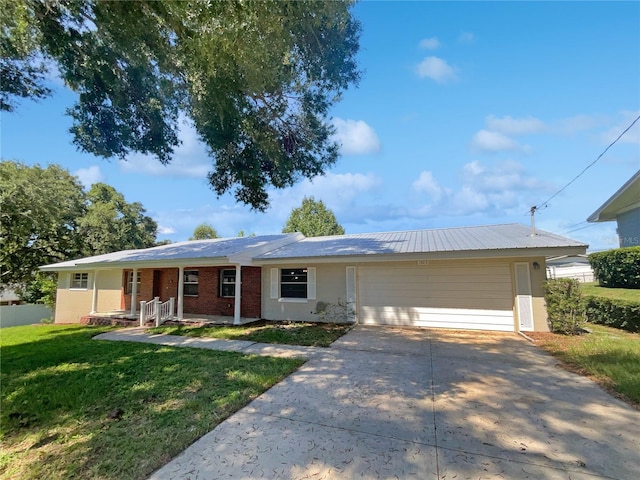 ranch-style home featuring an attached garage, concrete driveway, brick siding, and a front yard