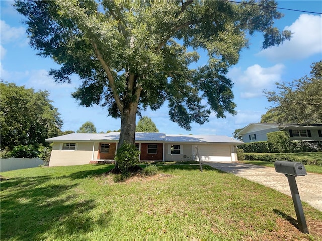 ranch-style house featuring a garage, a front yard, brick siding, and driveway