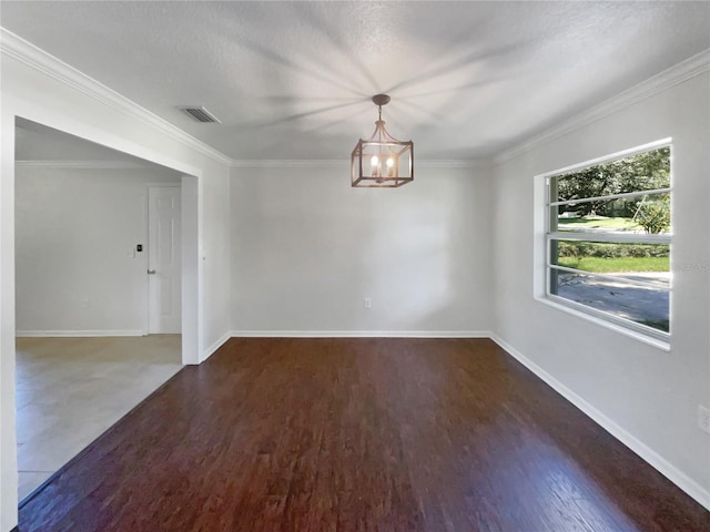 spare room with an inviting chandelier, visible vents, wood finished floors, and ornamental molding