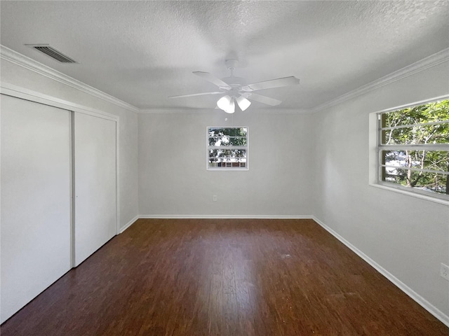 unfurnished bedroom featuring dark wood-style floors, multiple windows, visible vents, and ornamental molding