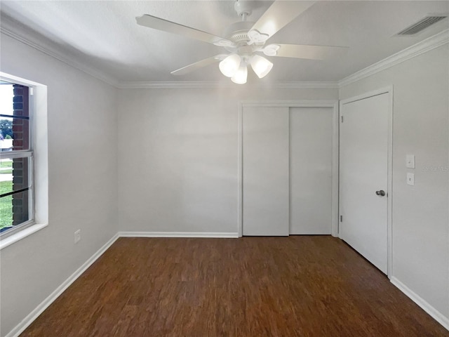 unfurnished bedroom with multiple windows, visible vents, and dark wood finished floors