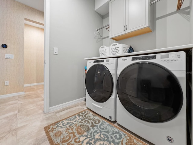 clothes washing area with light tile patterned floors, washing machine and clothes dryer, and cabinets