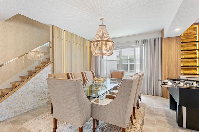 tiled dining room featuring a notable chandelier and a textured ceiling