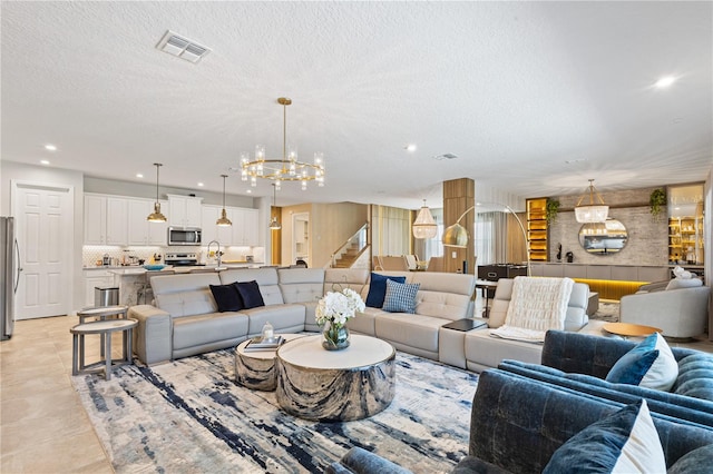 living room featuring sink, a notable chandelier, a textured ceiling, and light tile patterned floors