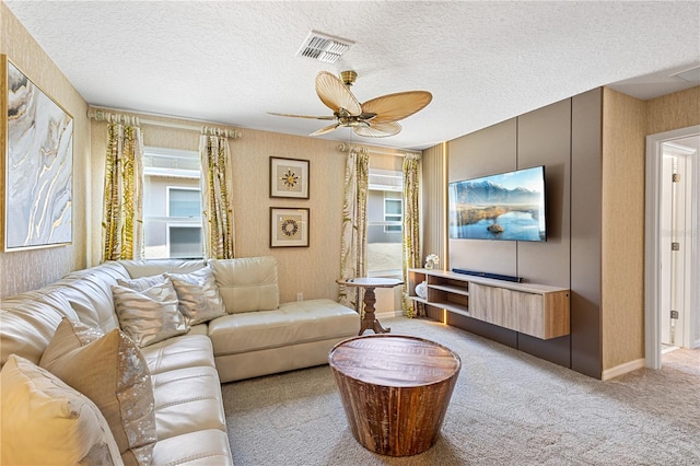 carpeted living room with a textured ceiling and ceiling fan