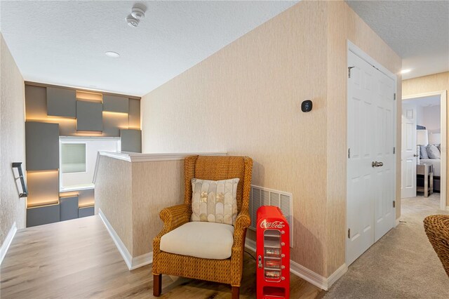 sitting room featuring light wood-type flooring and a textured ceiling