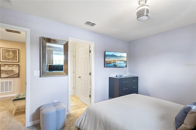 bedroom featuring a textured ceiling and light colored carpet