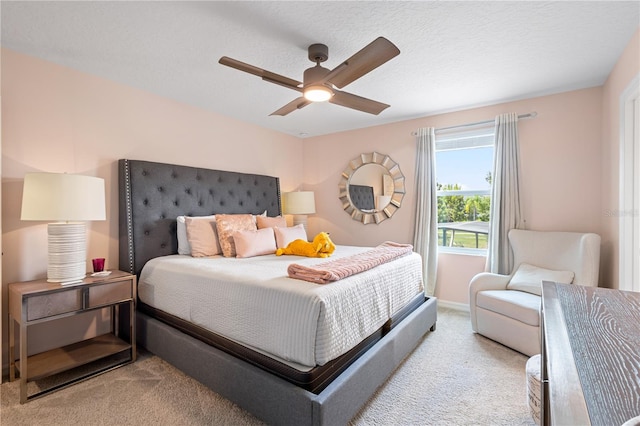 carpeted bedroom featuring a textured ceiling and ceiling fan